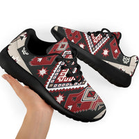 Sport sneakers on feet, red-brown tribal design with white accents, black laces