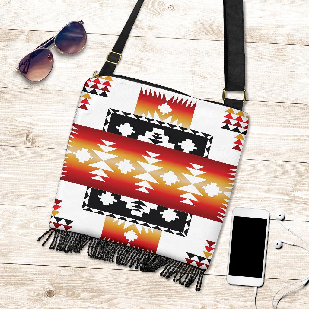 Flat lay: white tribal boho shoulder bag with red, black, gold aztec-style print fringe