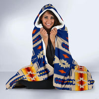 Navy hooded blanket with multicolor geometric pattern, hood up over head