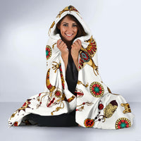 White hooded blanket with colorful Native-style symbol print, hood up and hands tucked inside