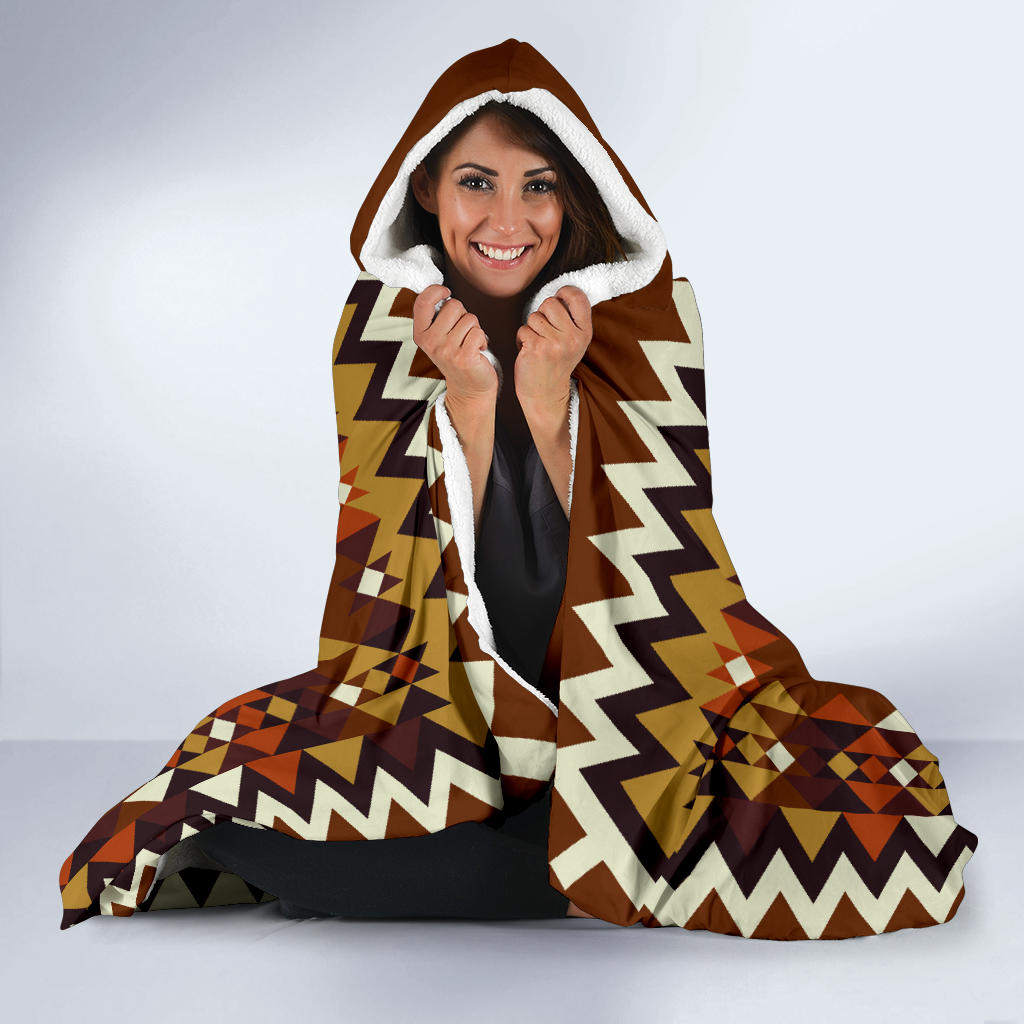 Brown hooded blanket worn with white-lined hood and zigzag patterned edges