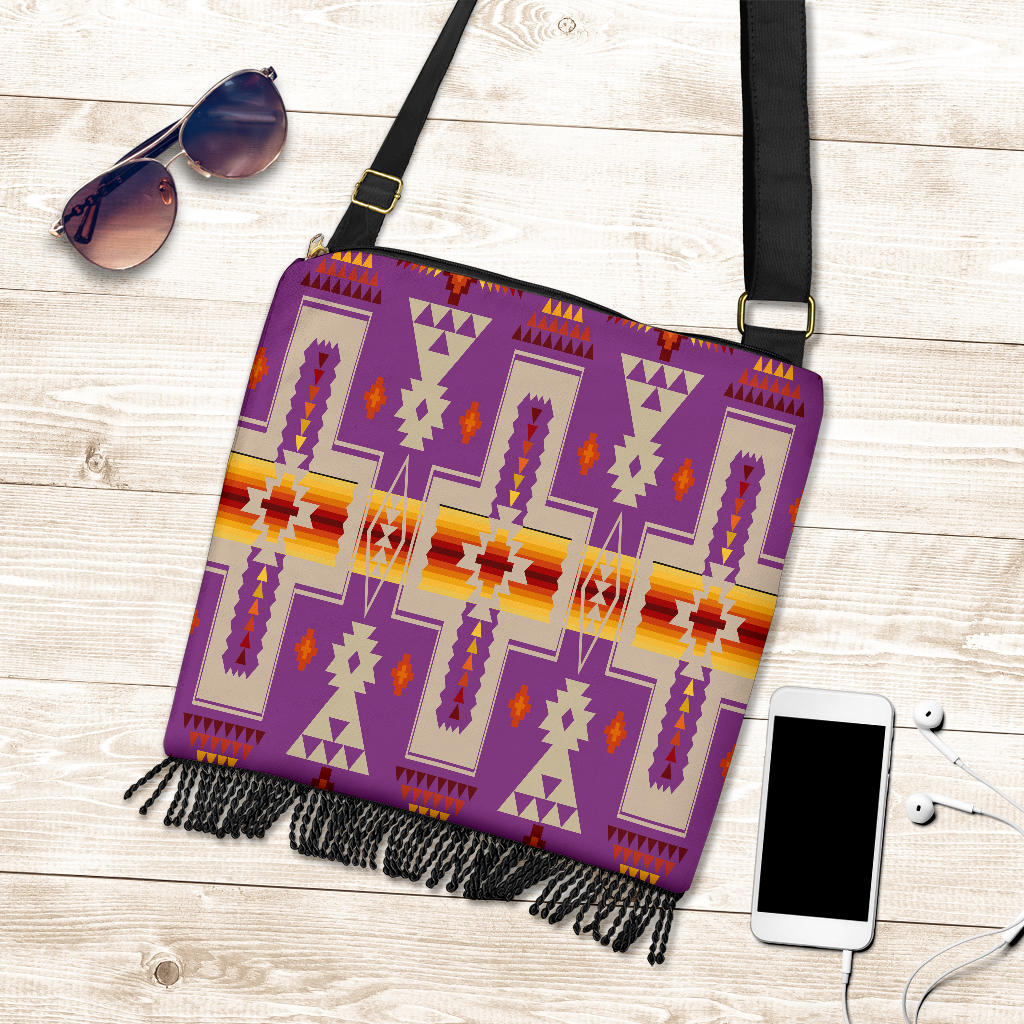 Flat-lay crossbody bag with purple geometric tribal pattern, black fringe, black strap