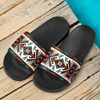 Pair of black slide sandals with white, red, and green tribal geometric straps