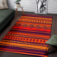 Orange patterned area rug with zigzag and diamond geometric designs in striped bands.