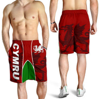 Red men’s Wales shorts on model; Cymru dragon crest, green side stripe, elastic waist