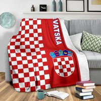 Red checkerboard half-style blanket draped on sofa with crest and “Hrvatska”
