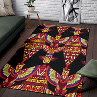 Black area rug with red, blue, yellow winged ornamental pattern in repeating star shapes