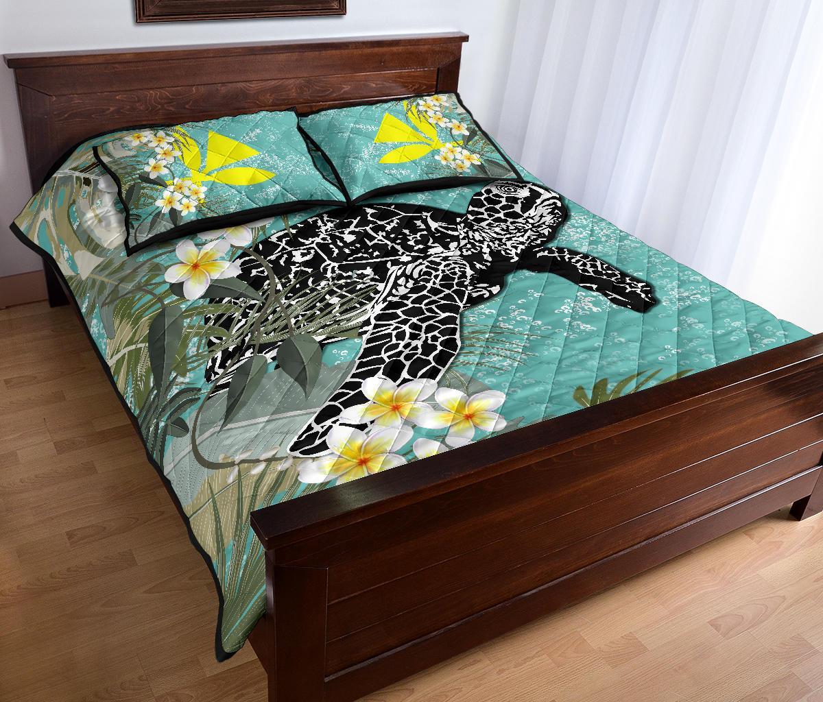 Teal quilt and pillow set featuring a black turtle with white pattern and plumeria blossoms