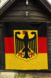 Quilt hanging on wall: quilted black top with eagle emblem, red and yellow stripes