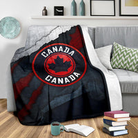 Canada blanket over sofa, grunge map pattern and red maple-leaf emblem in circle