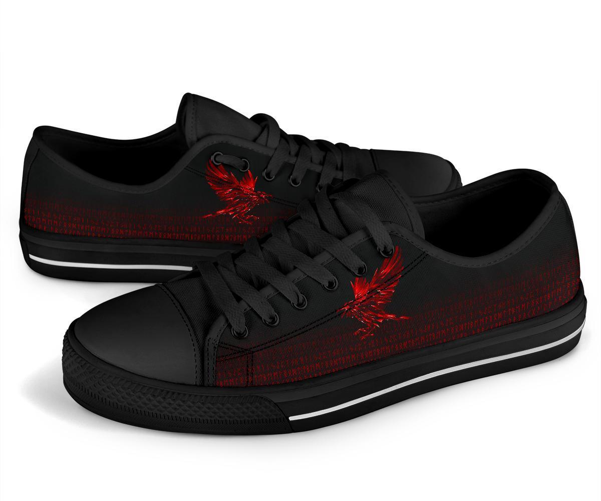 Black low-top sneakers with red rune artwork, angled view showing lace eyelets