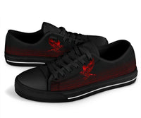 Black low-top sneakers with red rune artwork, angled view showing lace eyelets