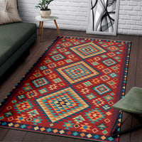 Colorful geometric area rug featuring diagonal diamonds on a dark red base