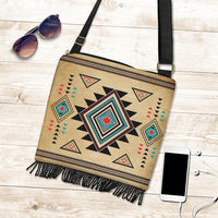 Tan southwest crossbody bag with bold diamond motif, zipper edge, and dangling fringe