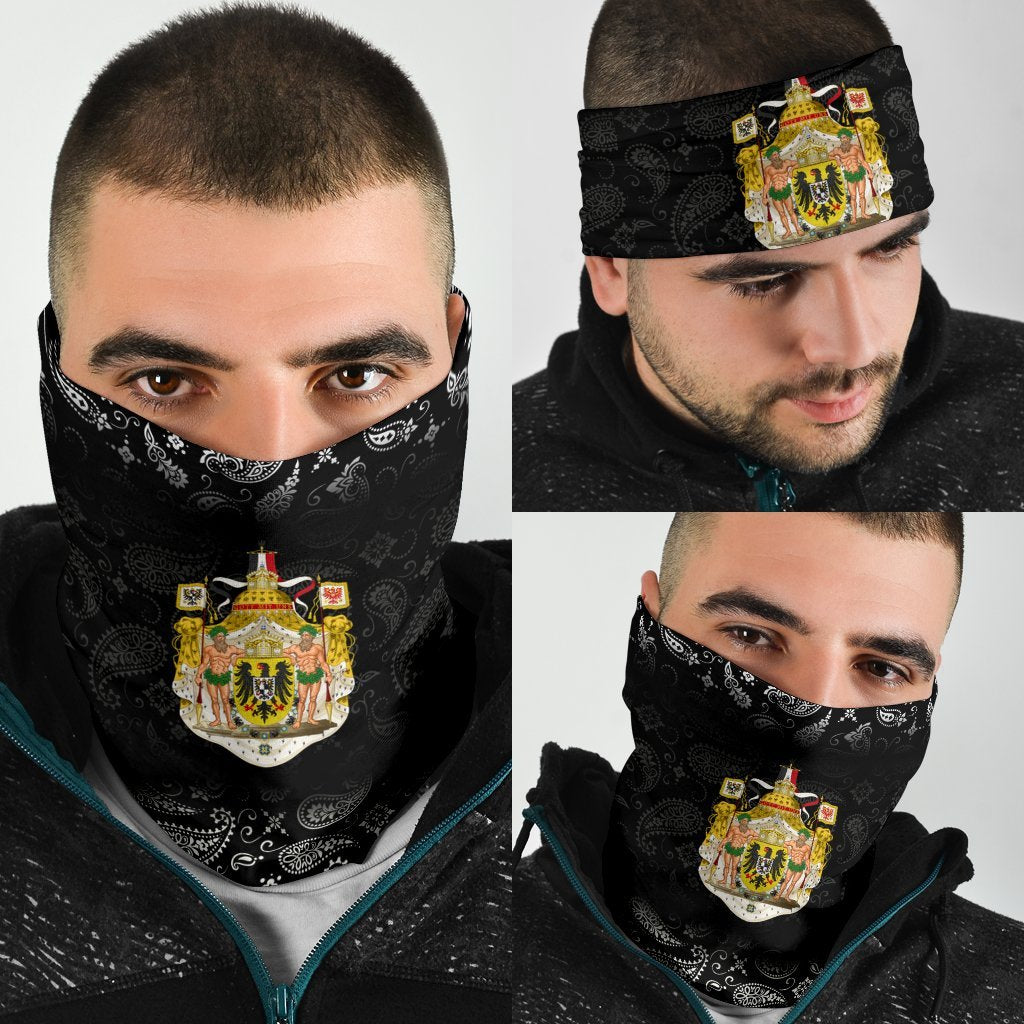 Black paisley neck gaiter with colorful coat-of-arms emblem, worn on face