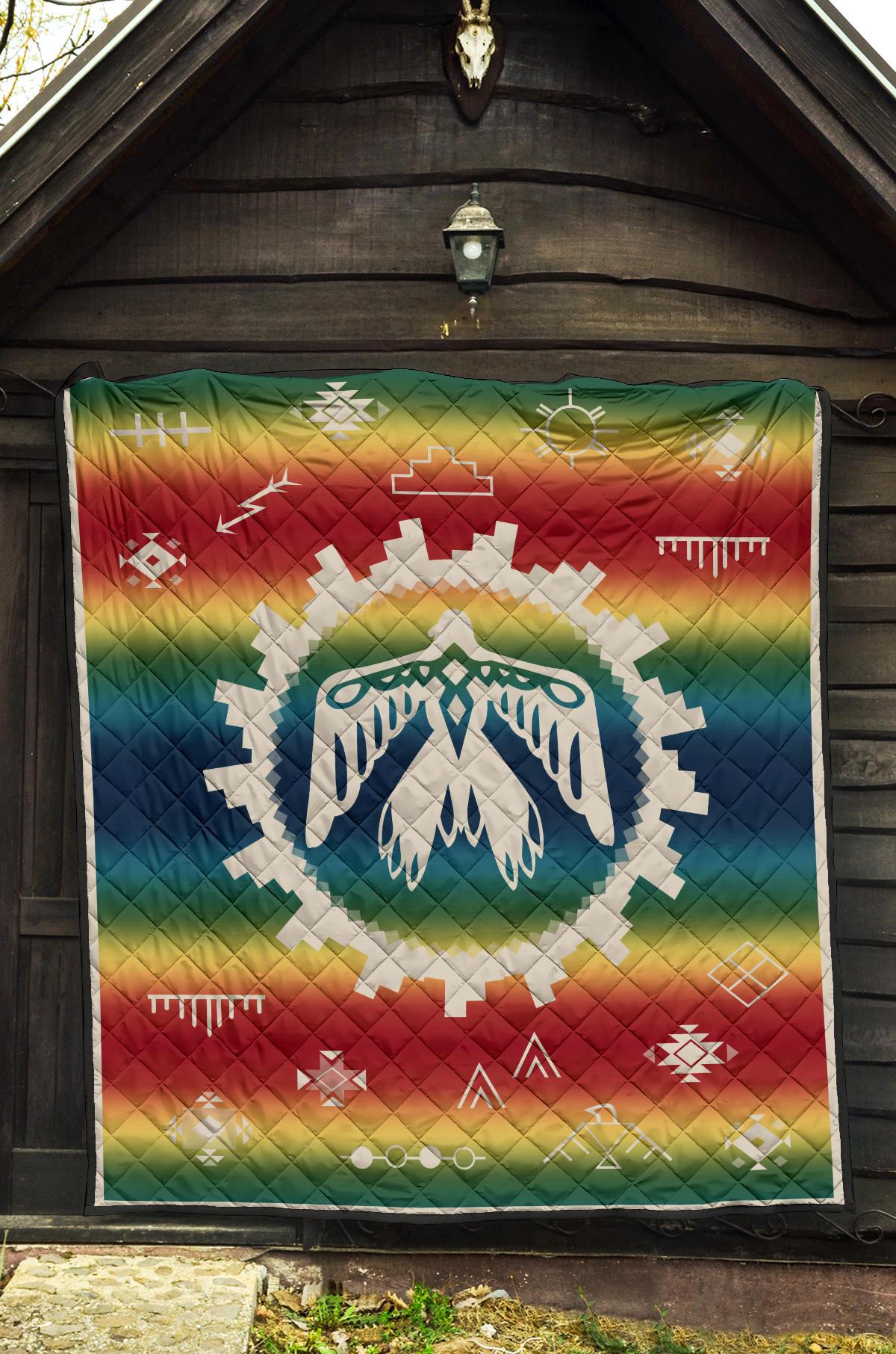 Rainbow thunderbird quilt with geometric shapes and white center emblem on quilt backing