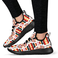Mesh knit sneakers on feet, red-orange tribal pattern and black sole