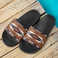 Pair of black slide sandals with brown-and-white geometric tribal print straps