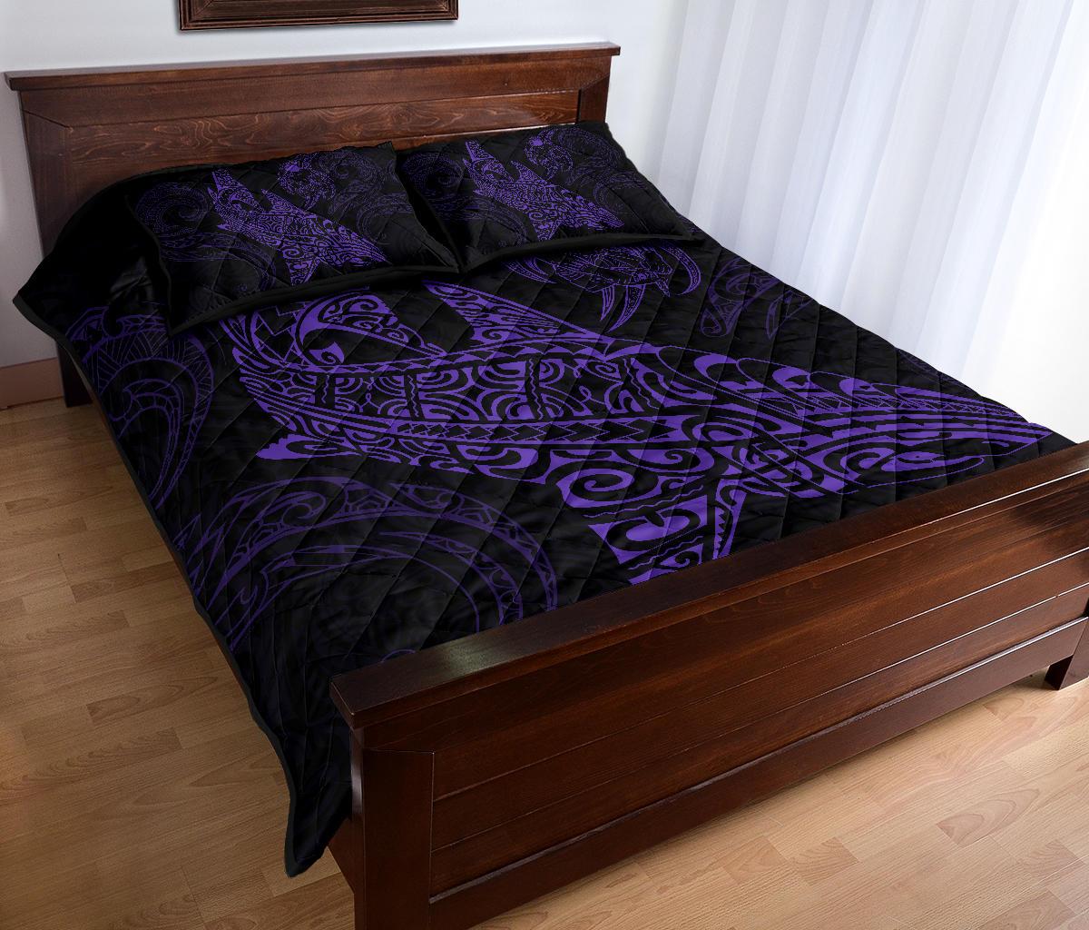 Black quilt bed set with purple Polynesian shark warrior pattern and 2 pillows, angled view