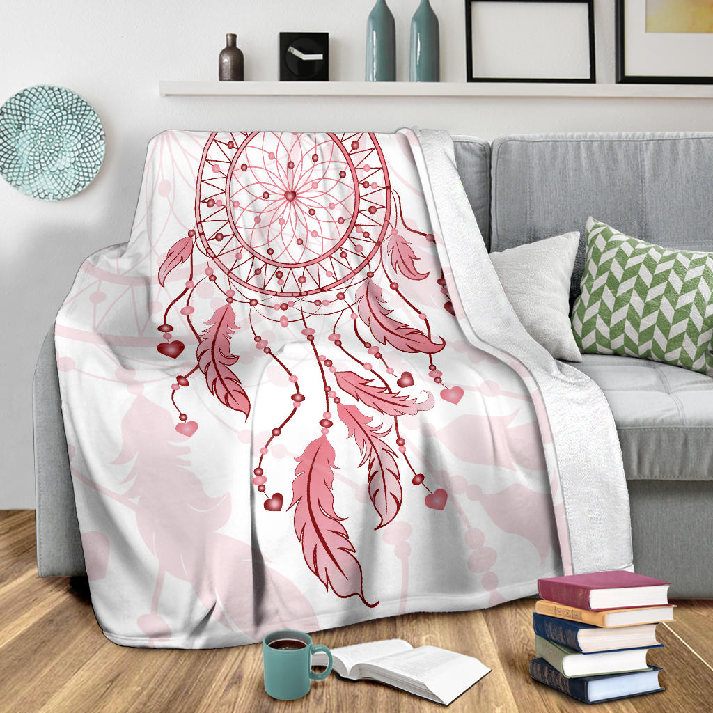 Pink dream catcher blanket draped on couch, showing large hoop and hanging feathers motif