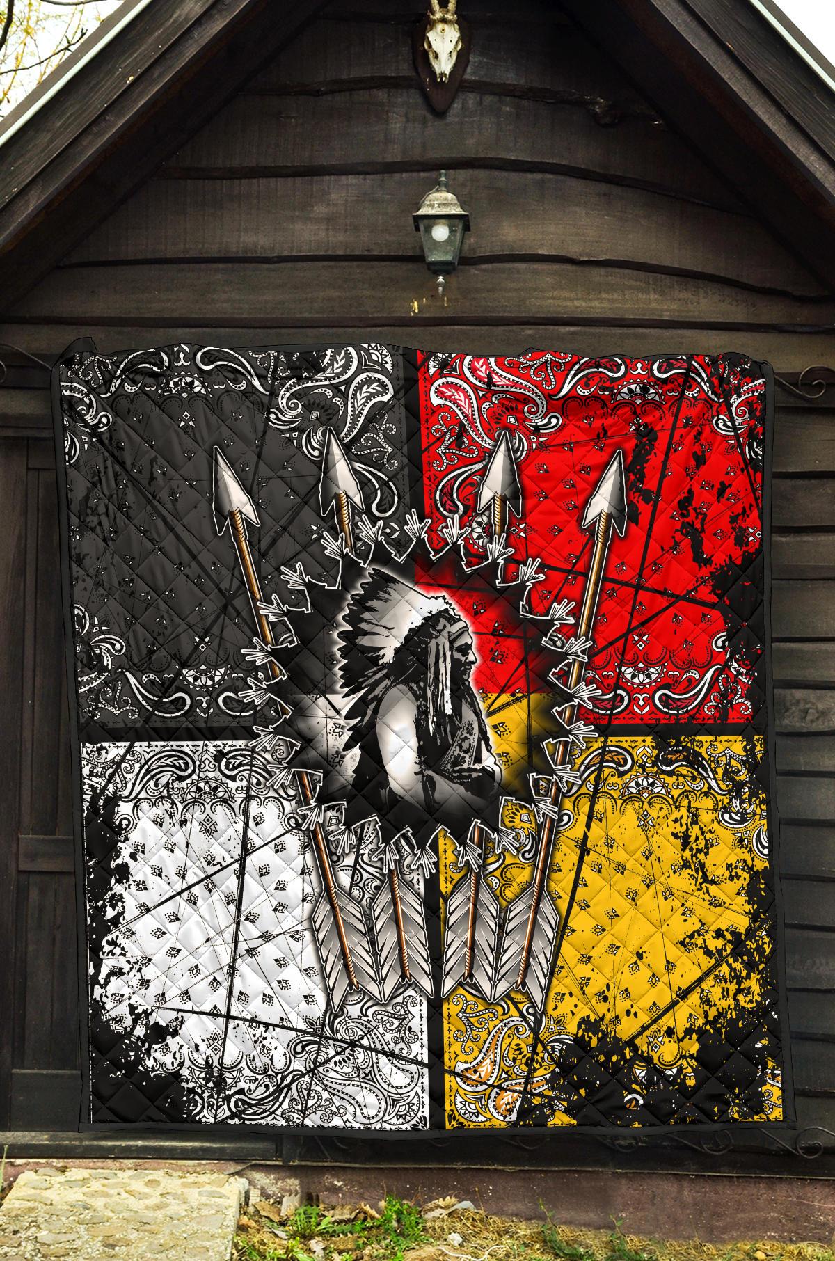 Chief Arrow quilt hanging on wall: black, red, yellow panels with central feathered figure