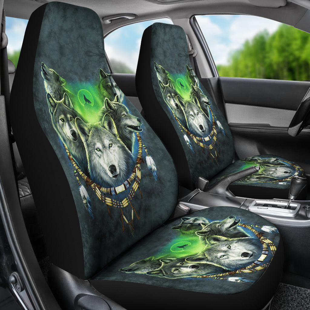 Angled car interior view of dark teal seat covers with green glow wolves and moon print