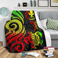 Reggae turtle blanket spread on gray couch, black base with bright green red yellow artwork