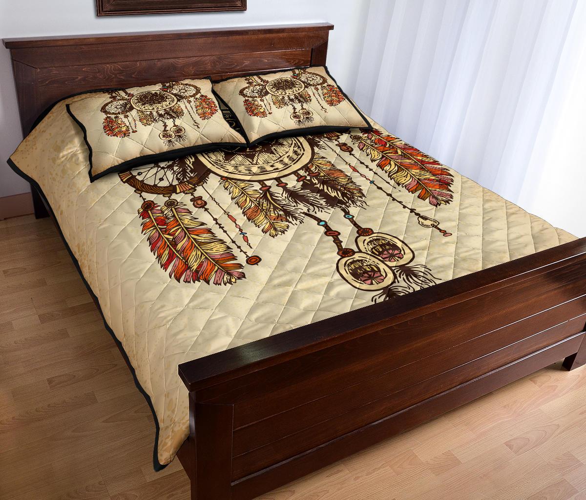 Dreamcatcher quilt bed set on dark wood bed frame, tan cover with multicolor feather print