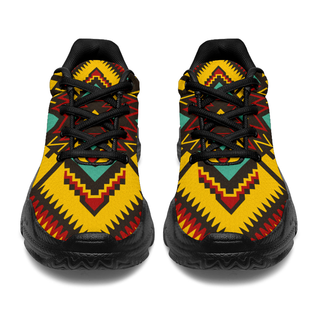 Front view chunky sneakers in yellow with red and teal geometric ornament, black laces