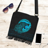 Black crossbody handbag with cyan wolf graphic, dangling chain fringe, front strap