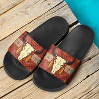 Pair of black slide sandals with brown bison skull patterned straps