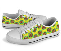 Angled low-top sneakers, green/yellow Ankara spiral print on white upper, white sole