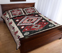 Quilt bed set with red, black, and white medallion center, outlined by geometric borders