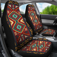 Colorful patterned seat covers on both front seats with console and steering visible
