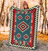 Geometric patterned blanket in teal with red and black diamond shapes and zigzag border