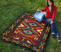 Folded Native American quilt showing teal and red diamond motifs with multicolor border