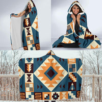 Navy hooded blanket with Native-inspired arrow motifs, hood up while lounging