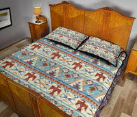 Light blue quilt bed set with red, tan, and navy triangle and arrow blocks; pillow shams