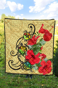 Beige quilt with black turtle graphics and quilted red hibiscus blooms on the corner edge
