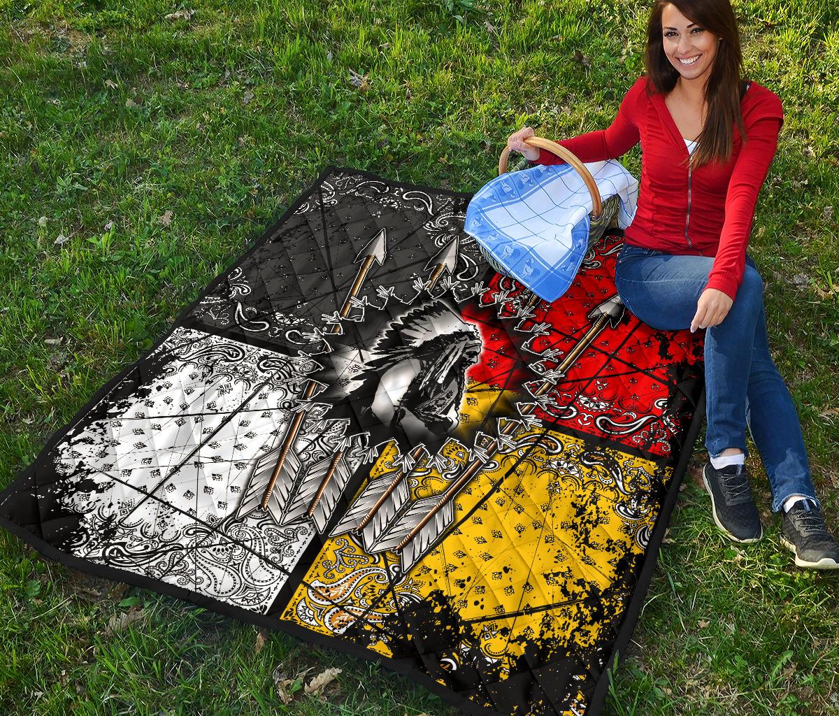 Folded Chief Arrow quilt on grass, multicolor design with black white red yellow arrow patterns