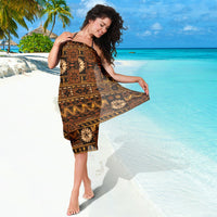 Brown tapa print sarong wrap with geometric motifs, held open at the side