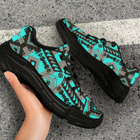 Chunky sneakers on feet, turquoise geometric tribal print over gray, black laces