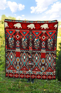 Outdoor quilt laid flat with white bears and red, black, turquoise native geometric pattern
