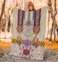 Purple breastplate blanket held up outdoors, with fringe details and beaded geometric designs