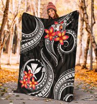 Black blanket draped outdoors with red plumeria and white Polynesian design