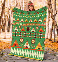 Green outdoor blanket held up, featuring tents, bison, and dreamcatcher circle pattern