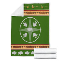 Folded green blanket with white medicine wheel emblem, multicolor striped border and bison
