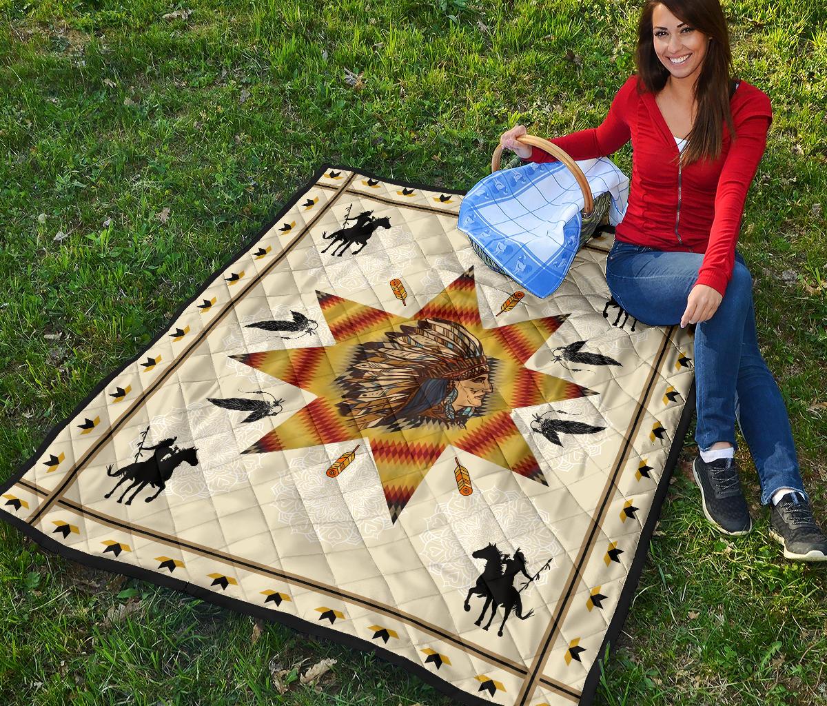 Native American chief quilt on grass: white fabric, red-yellow starburst, horses, birds, trim border