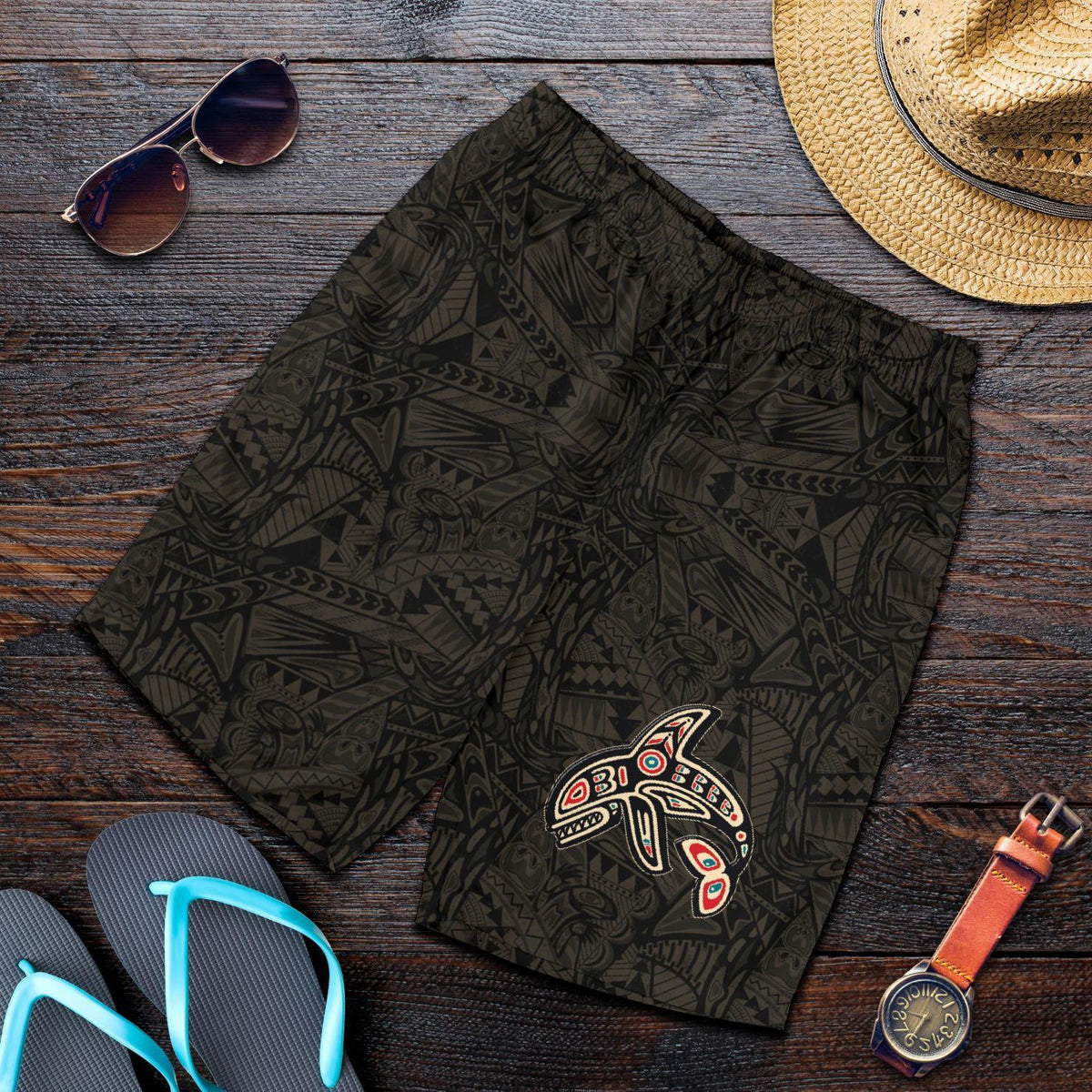 Black men’s shorts with dark tribal pattern and colorful killer whale graphic on leg