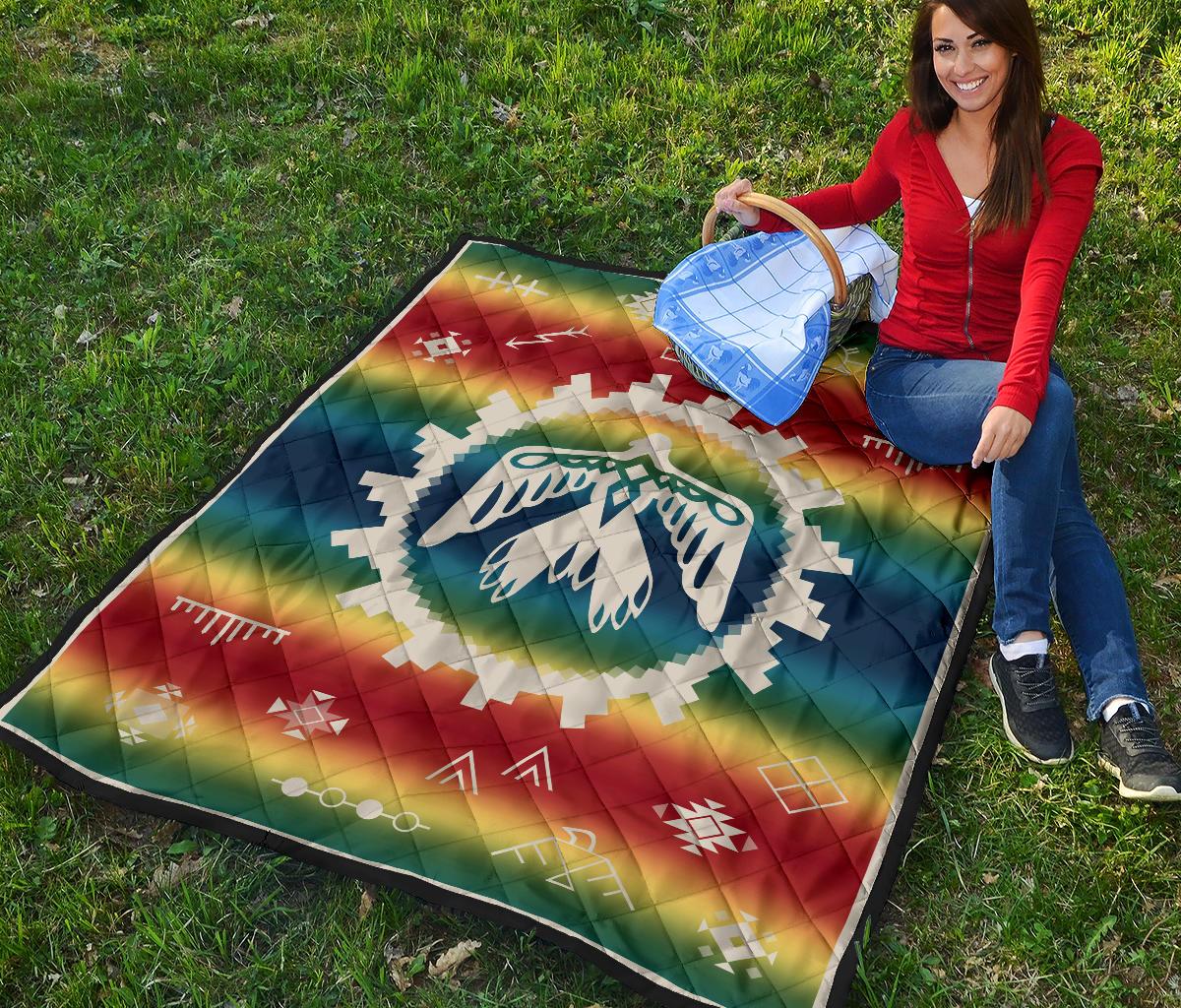 Colorful rainbow quilt with white thunderbird emblem, diamond and stripe patterns